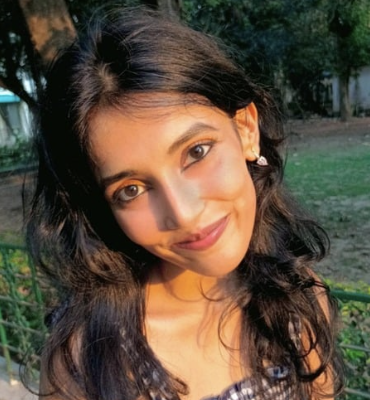 Professional headshot of Indian woman with shoulder-length black hair in blue blazer